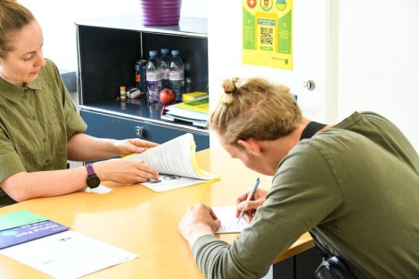 Ein Ukrainer f&uuml;llt in einem Beratungsgespr&auml;ch ein Formular aus. 