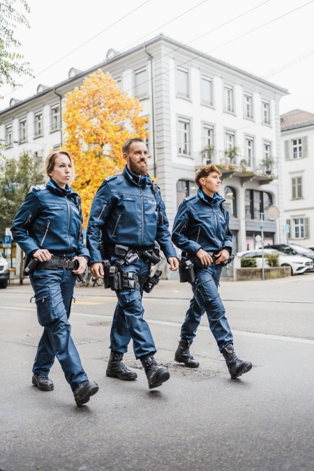 Eine Sicherheitsassistentin, ein Polizist und eine Polizistin auf der Poststrasse in St.Gallen.